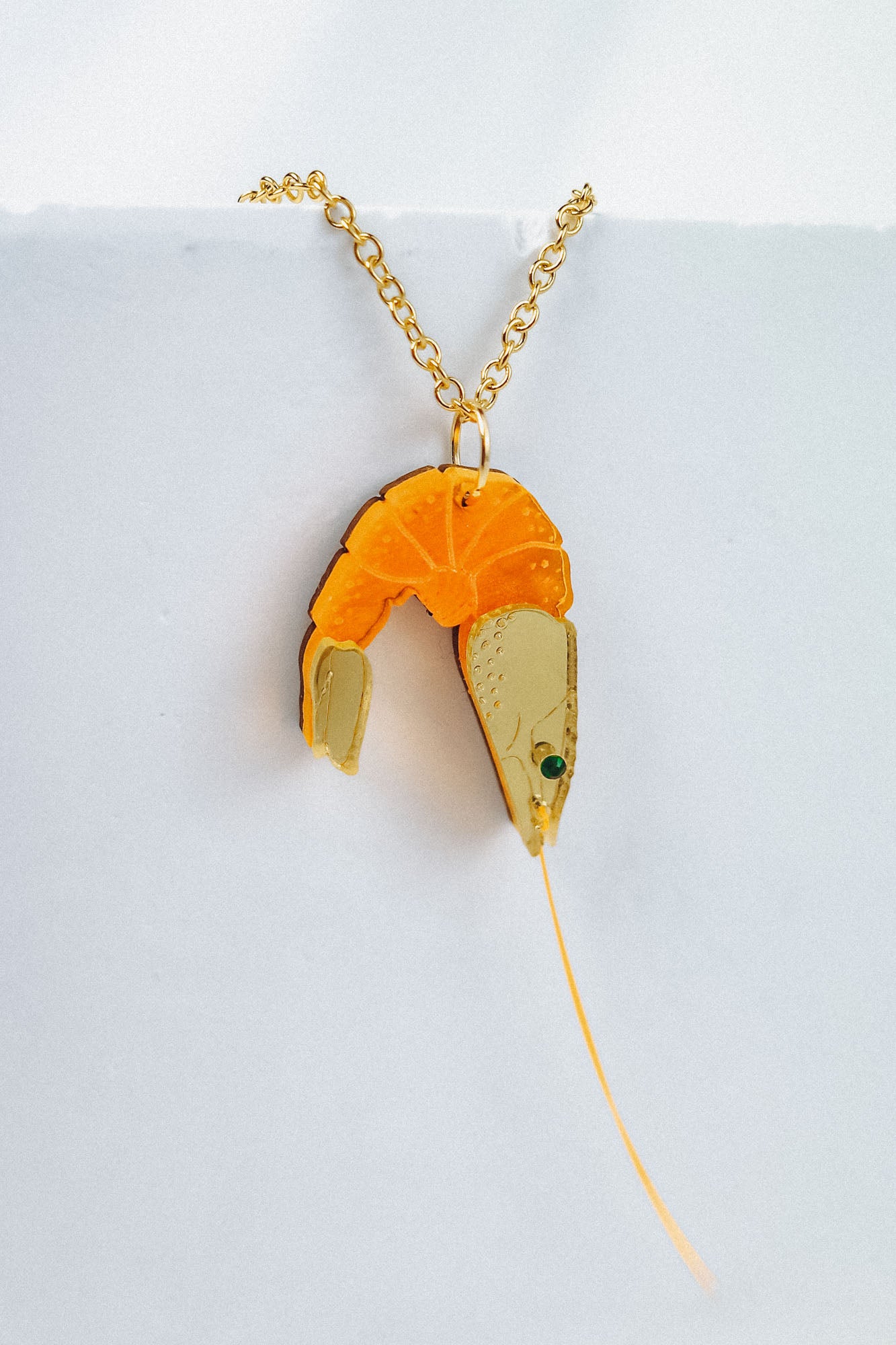 A whimsical gold Shrimp Pendant Necklace featuring a realistic orange and beige shrimp, displayed against a plain white background for a playful touch.